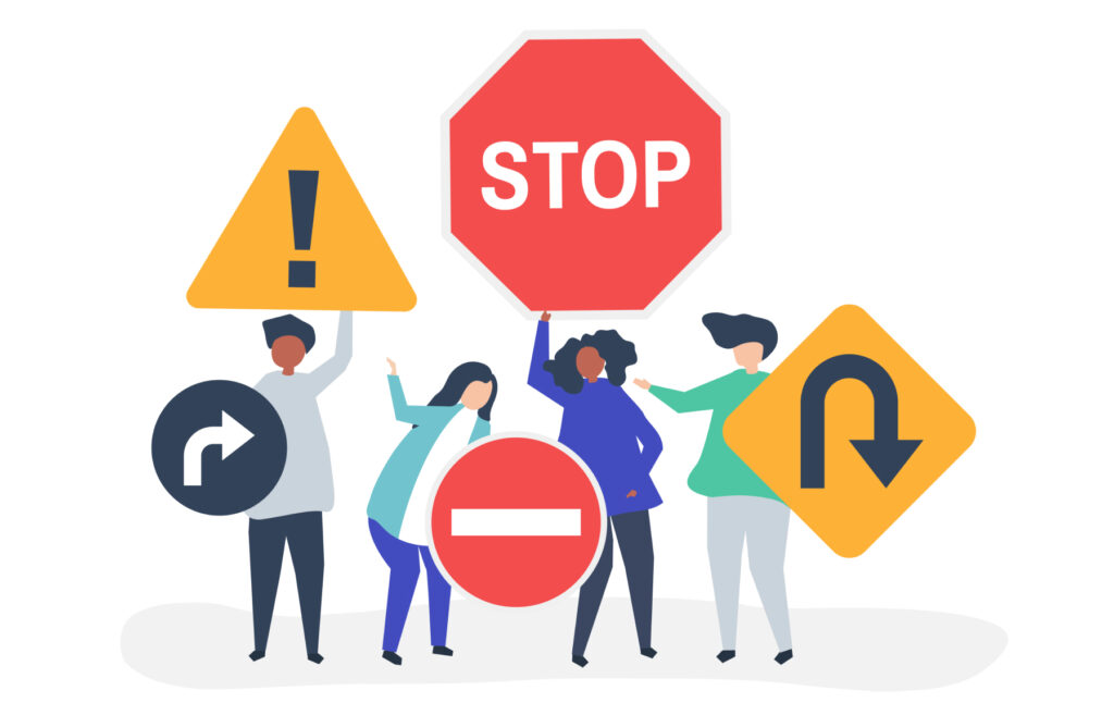 Four people holding up signs saying stop, turn around, and do not enter.