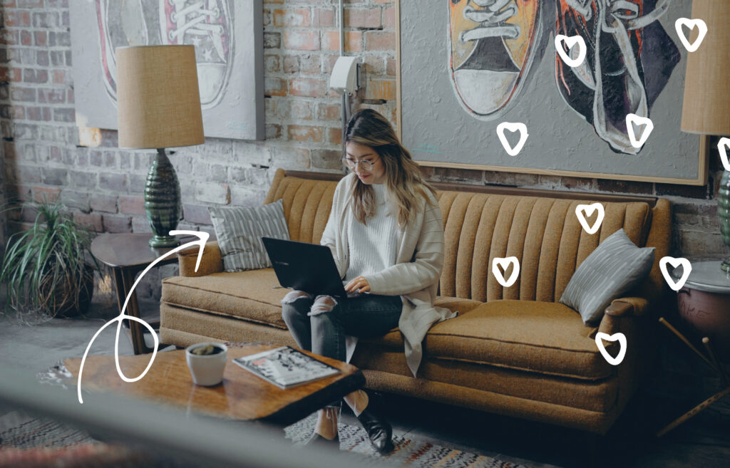 Person sitting on a couch working on a laptop in a cozy living room, with decorative heart doodles overlayed.